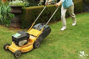 Front view of man cutting garden with lawn mower