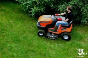 Mowing Lawn With Orange Ride On Mower